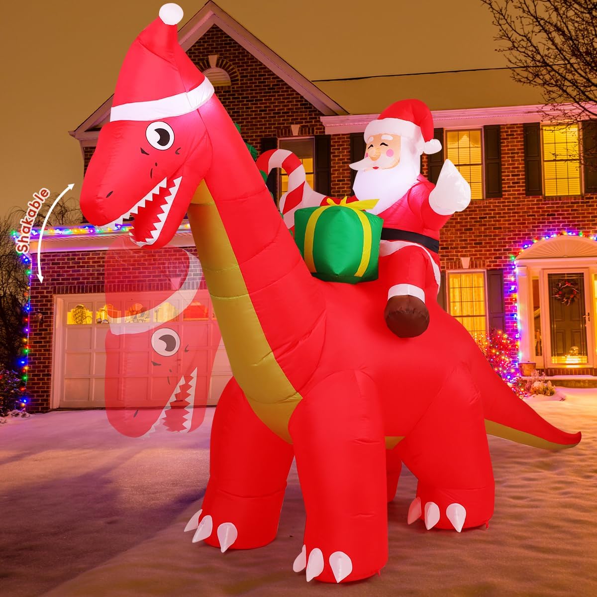 Santa riding a red dinosaur in a Santa hat, inflatable in front of a brick house
