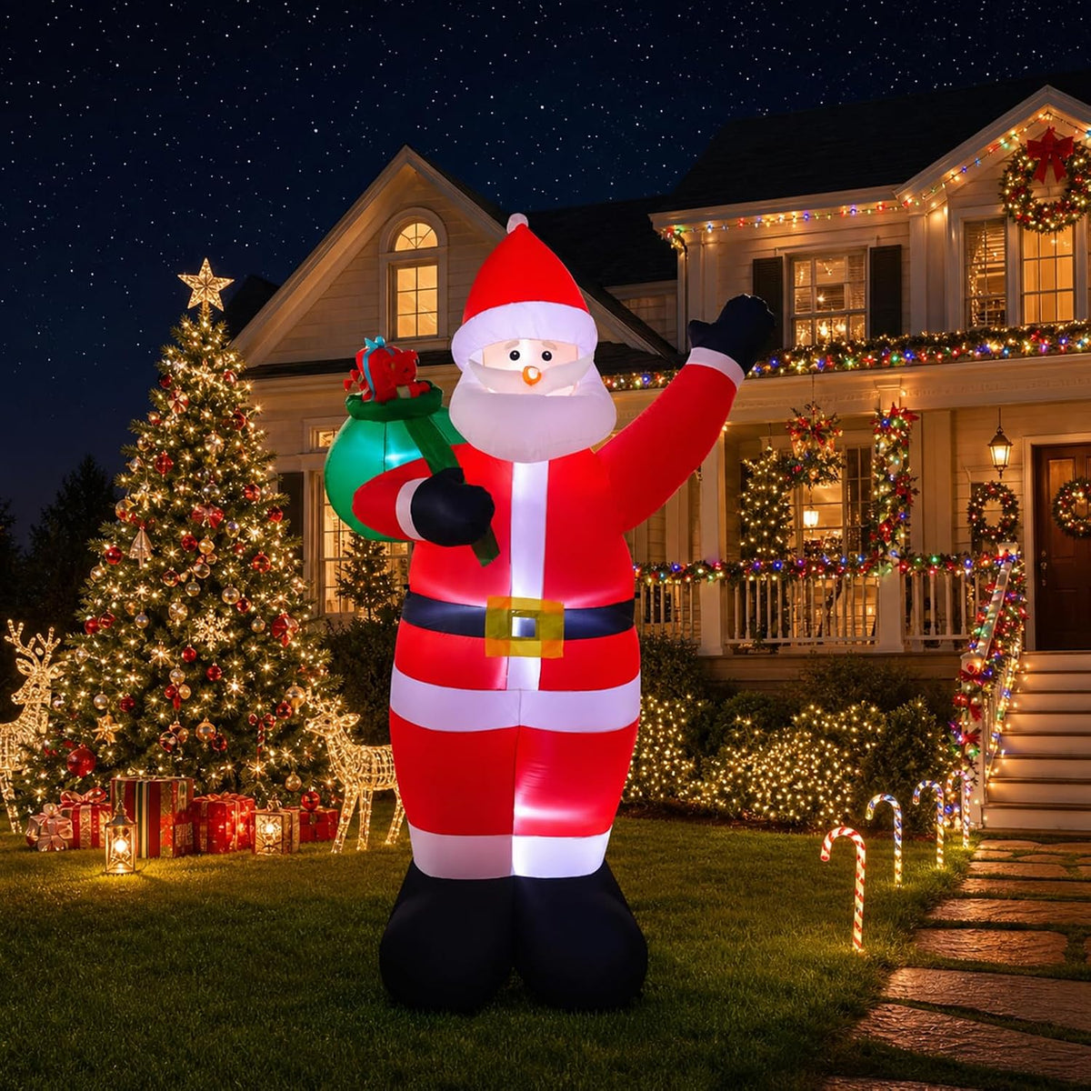 Waving Santa inflatable with a green gift sack in a front yard with a lit Christmas tree