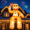 Gingerbread man inflatable sitting on a lit roof edge holding a peppermint with fireworks behind