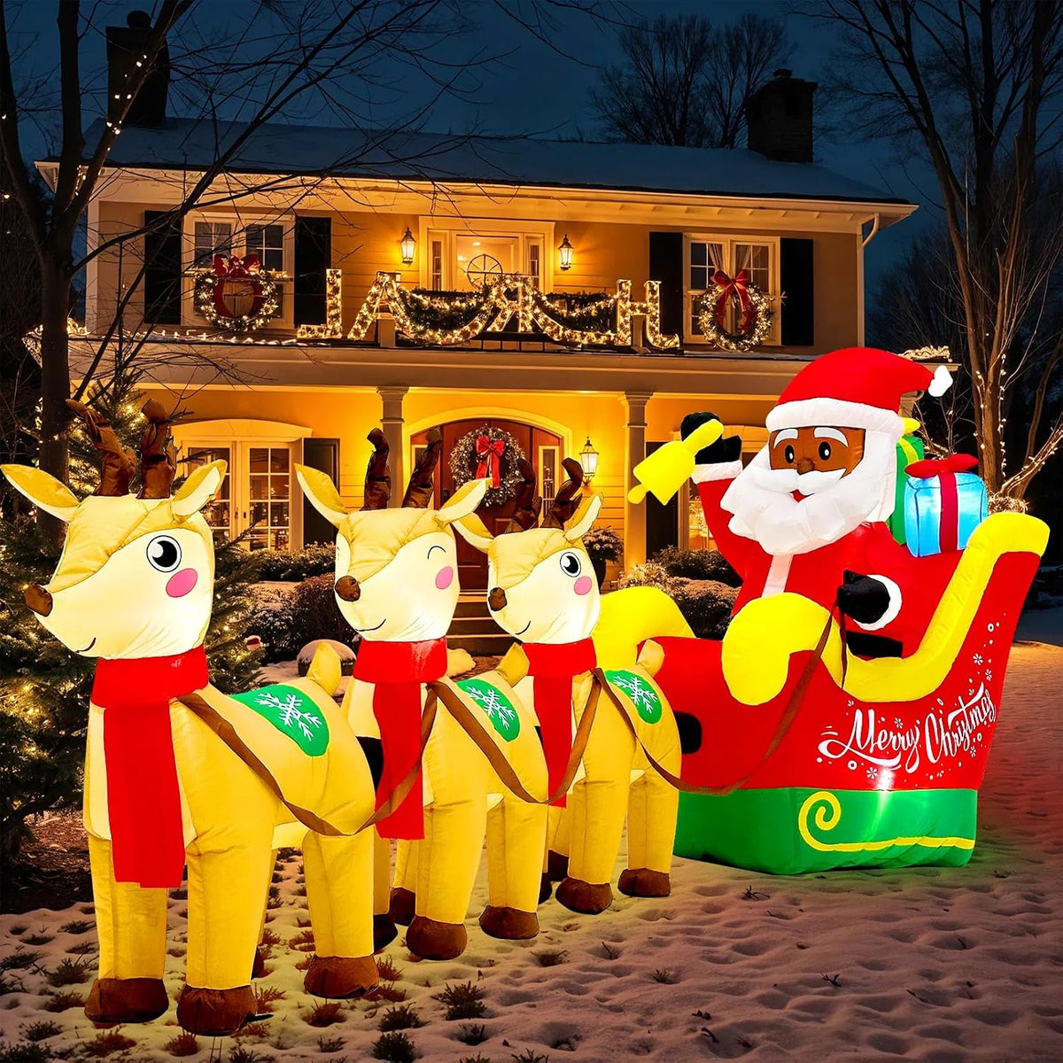 Black Santa inflatable waving from a red sleigh pulled by three reindeer in front of a lit house