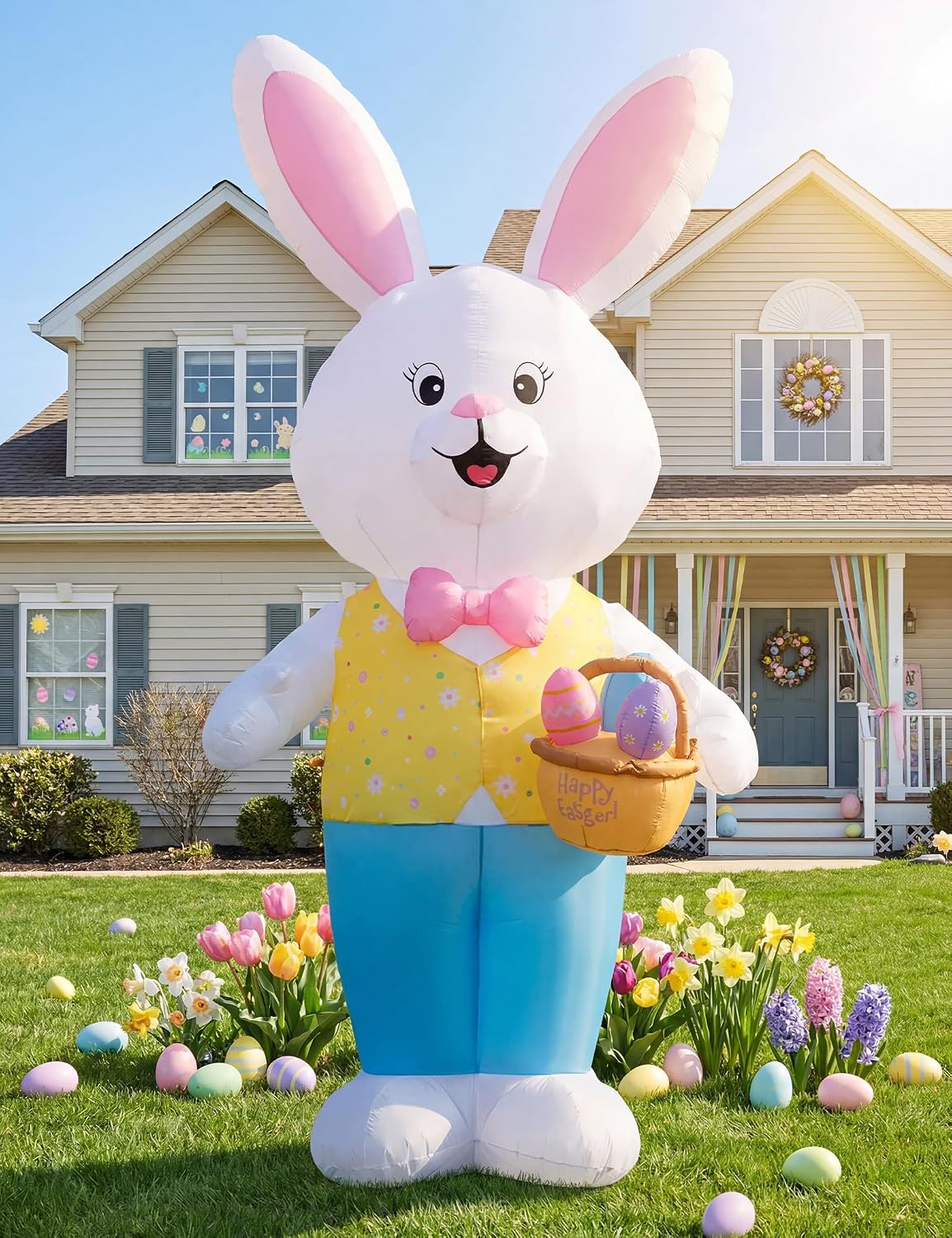 Giant white Easter bunny inflatable in a yellow vest holding an egg basket in front of a house