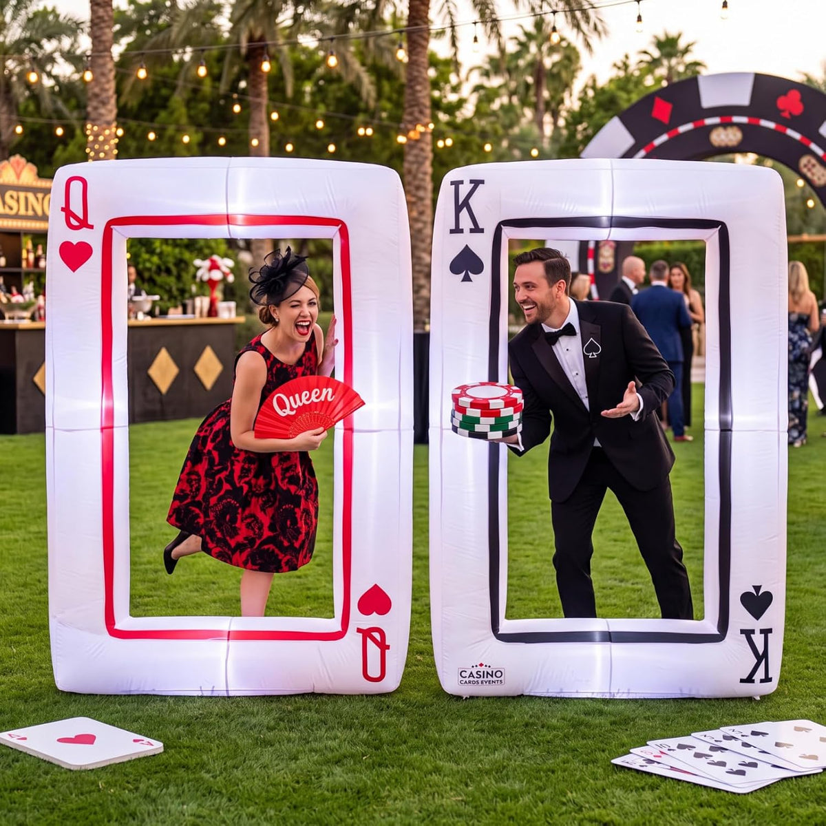 Two giant inflatable playing card frames, Queen of Hearts and King of Spades, with guests posing inside