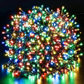 Dense bundle of glowing multicolor LED Christmas string lights on green wire