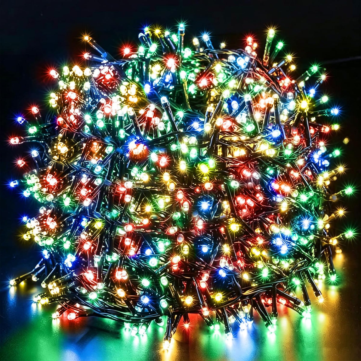 Dense bundle of glowing multicolor LED Christmas string lights on green wire