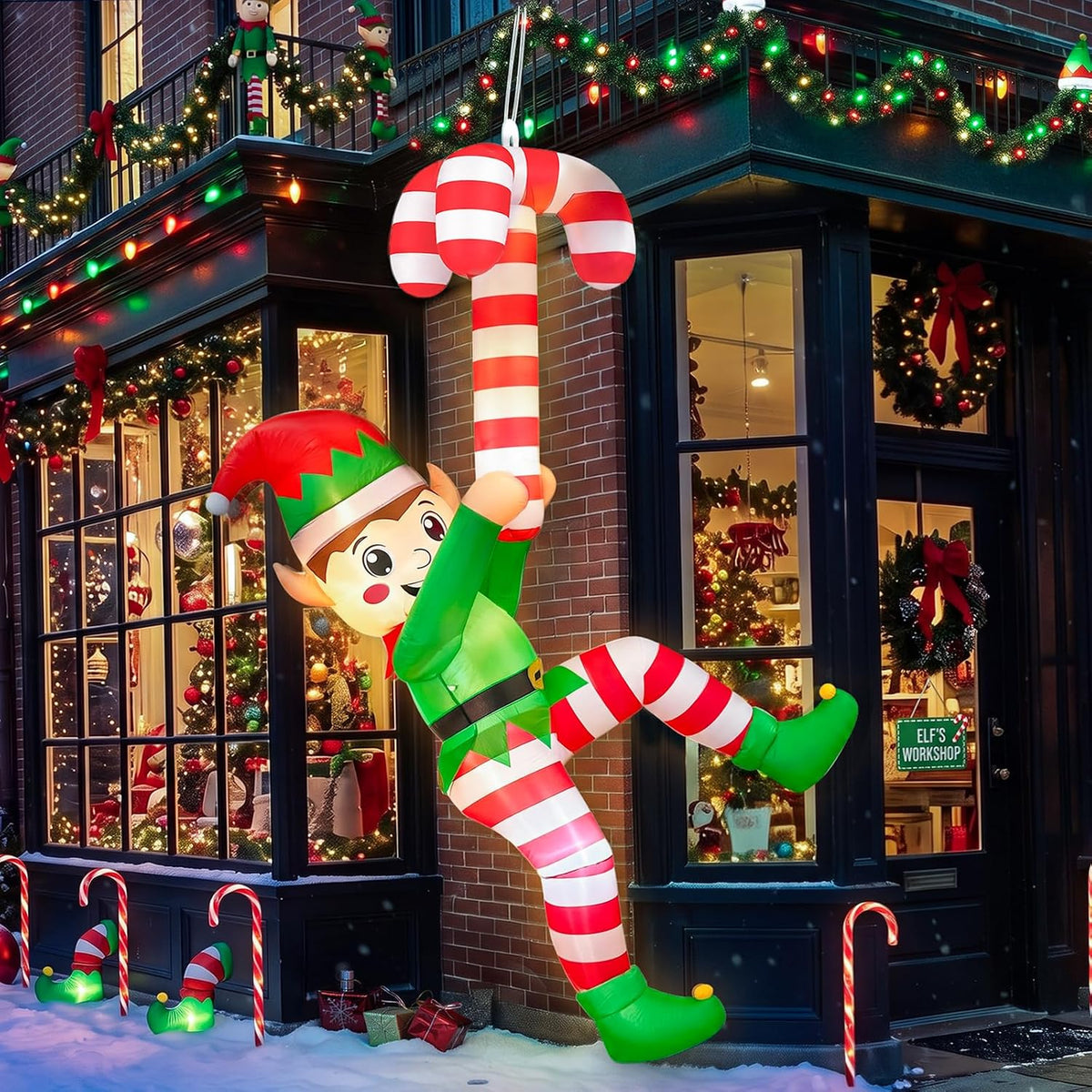 Elf inflatable in green with striped legs hanging from a giant candy cane on the front of a building