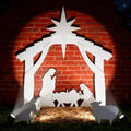 White silhouette nativity scene with a star, the Holy Family, the manger and animals in front of a brick wall