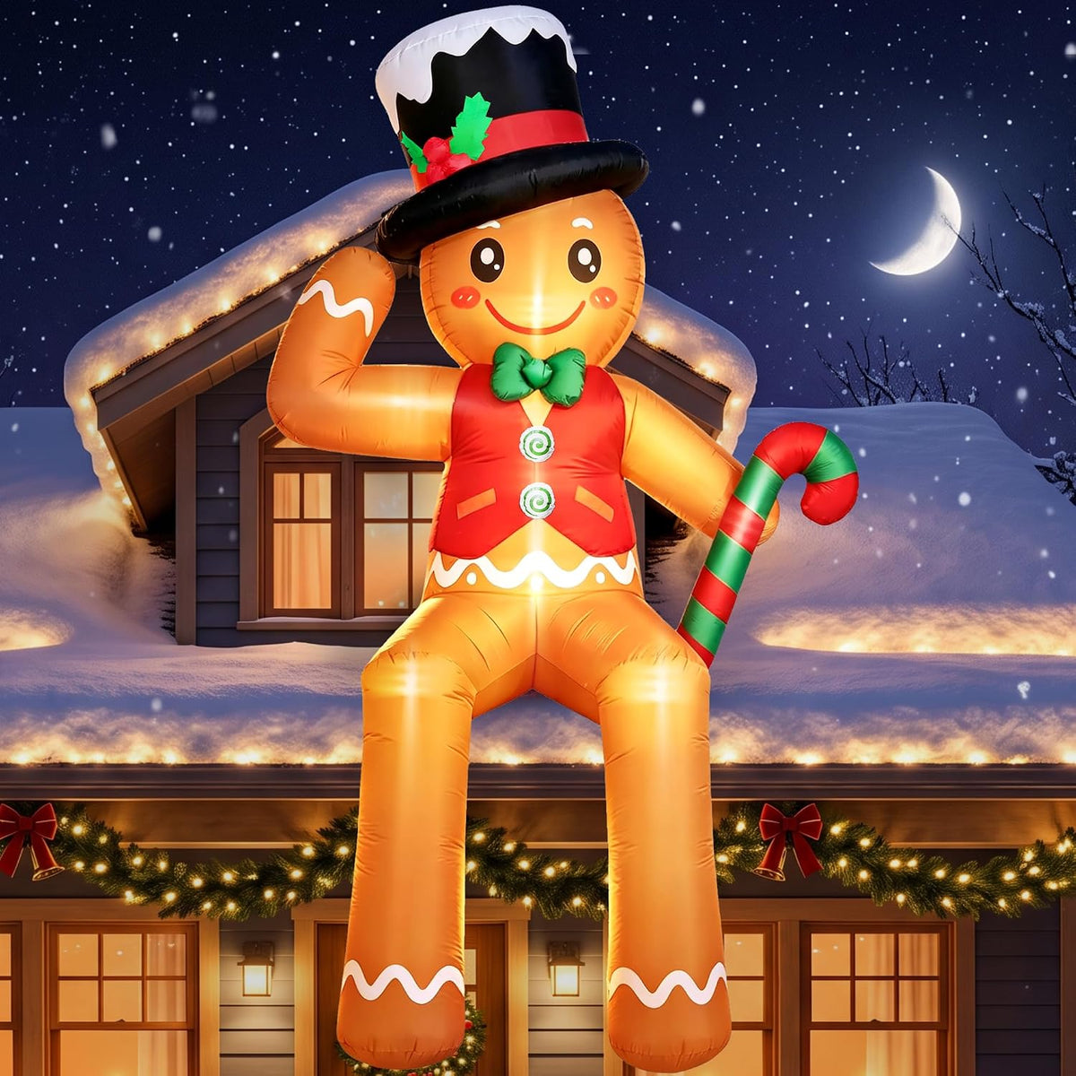 Giant gingerbread man inflatable in a top hat sitting on a snowy roof edge waving at night