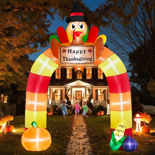 Striped Thanksgiving arch inflatable with a turkey and Happy Thanksgiving sign over a front walk at dusk