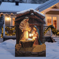 Painted nativity panel in a stable shape with Mary, Joseph holding a lantern and the baby in the manger in a snowy yard