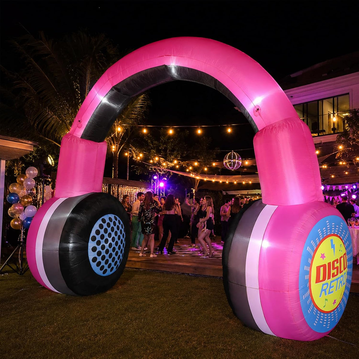 Giant pink headphones inflatable arch at a nighttime outdoor party